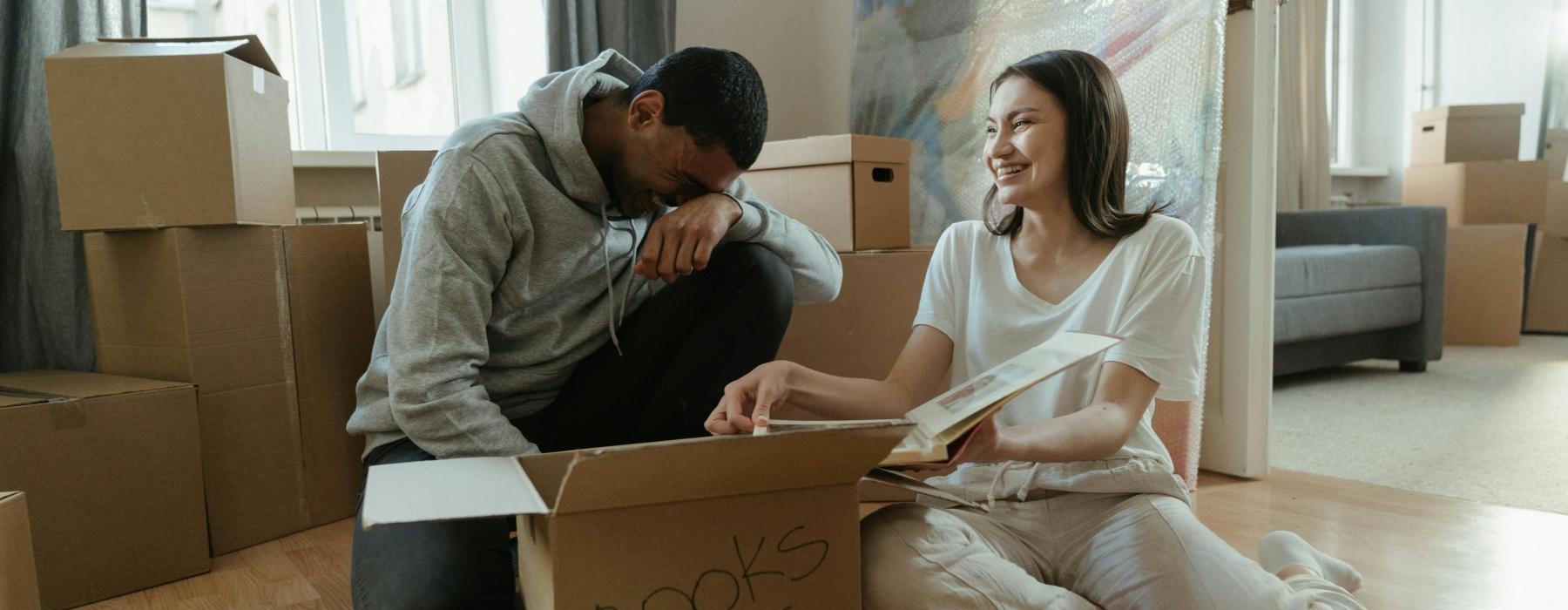 a man and a woman sitting on the floor with boxes and a map
